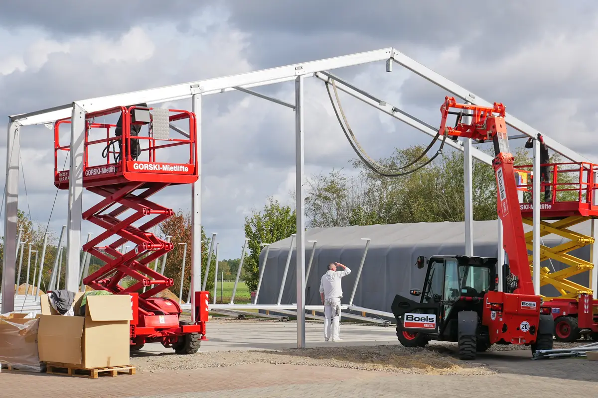 Bild Aufbau der Metallträger für die neue Lagerhalle mit Kran und Hubwagen