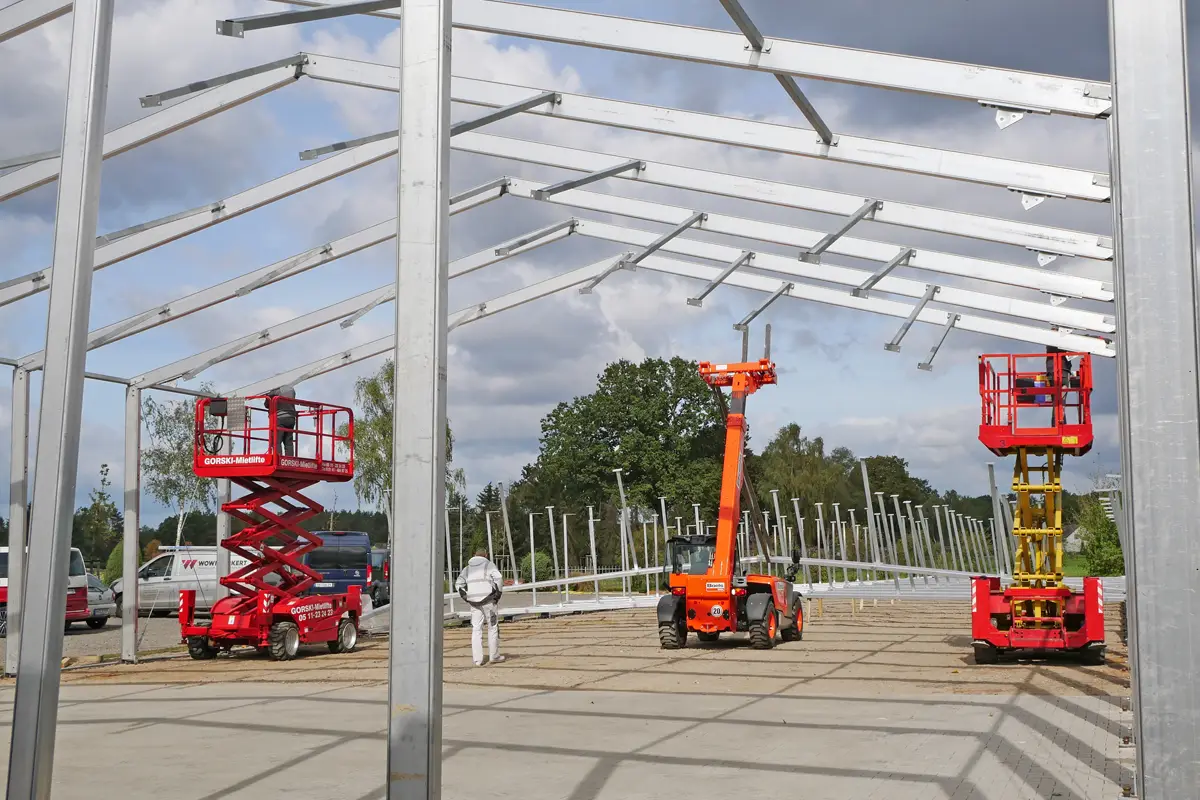 Bild Errichtung der Metallträger für die neue Lagerhalle mit Kran und Hubwagen